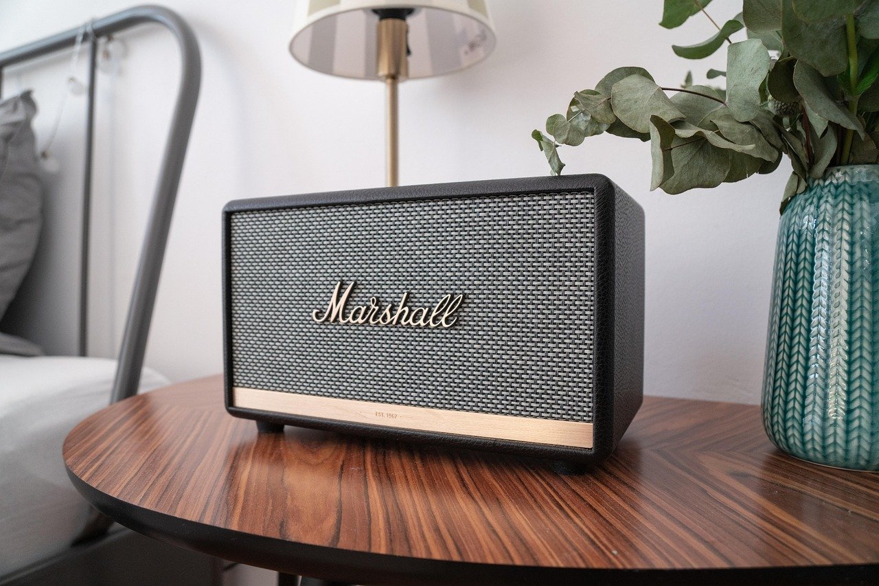 Caixa de som bluetooth sobre mesa, ilustrando teste de conexão em ambiente livre de interferência