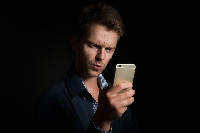 Celular Samsung com tela apagada sobre mesa em ambiente escuro