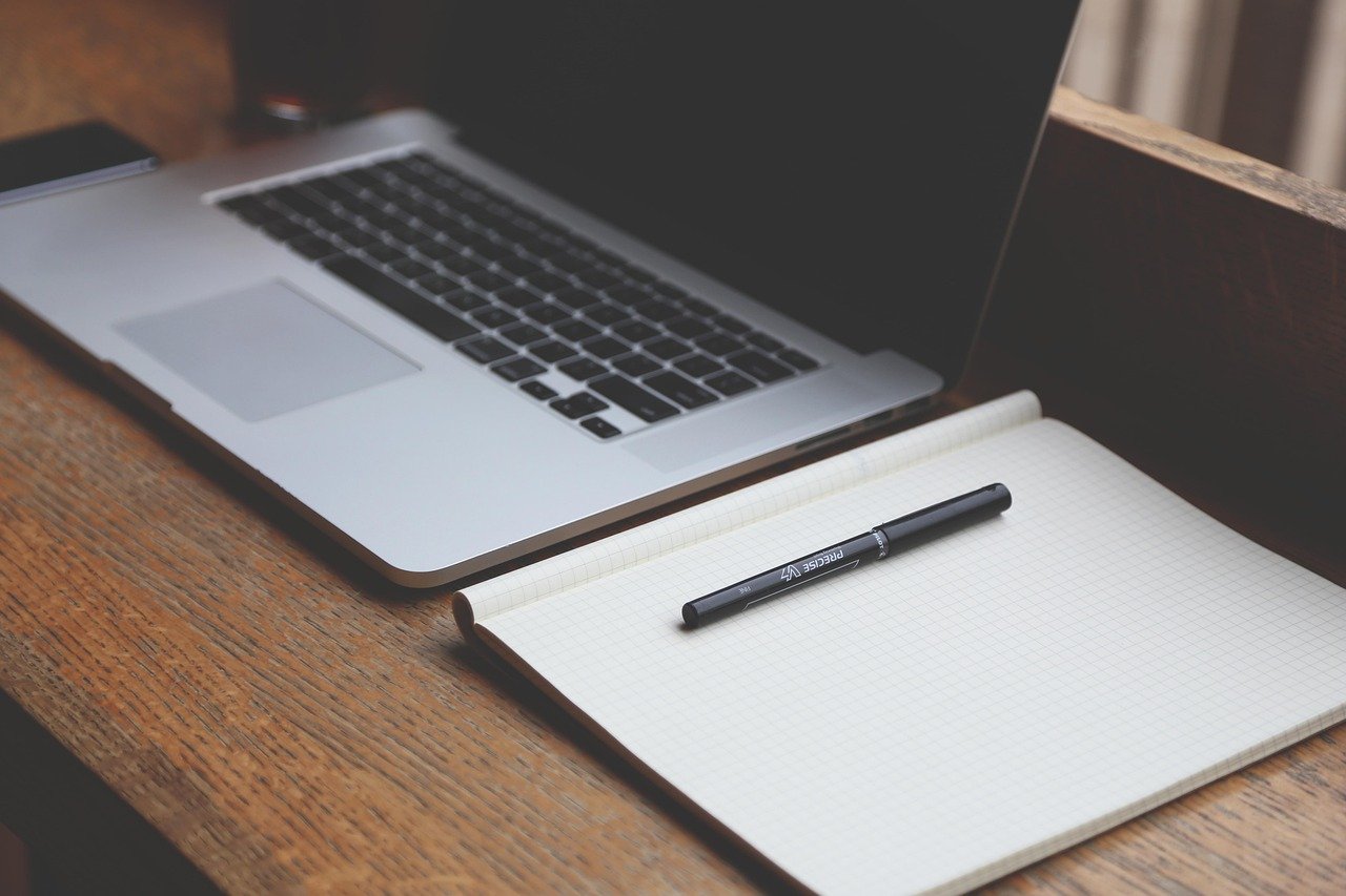 MacBook aberto sobre mesa com tela acesa, ilustrando verificação de desempenho e processos no Monitor de Atividade