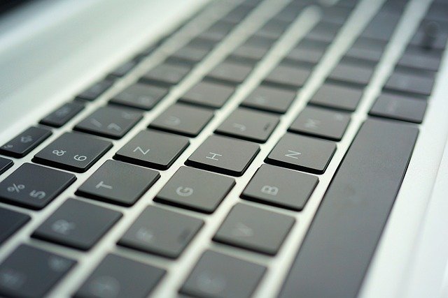 Teclado de notebook em uso próximo, ilustrando verificação de teclas do teclado